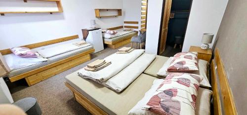 a group of three beds in a room at Penzion u Marešů in Hřensko