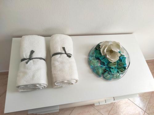 - une table blanche avec des serviettes et un bol de fleurs dans l'établissement Casa Crispi, à Chioggia