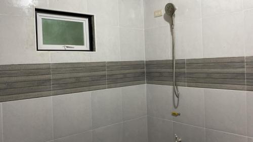 a shower in a bathroom with a green window at The Brookside Cottage Sta Magdalena Sorsogon 