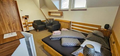 a small room with a bed and a chair at Penzion u Marešů in Hřensko