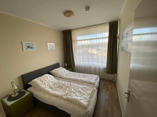 two beds in a room with a window at Texel-De Koog 116 in De Koog