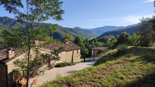 a road in a village with mountains in the background at Ca' dei Giuli Apartments in Mercatello sul Metauro