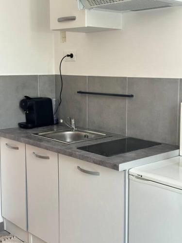 a kitchen with a sink and a counter top at Studio Melun in Melun