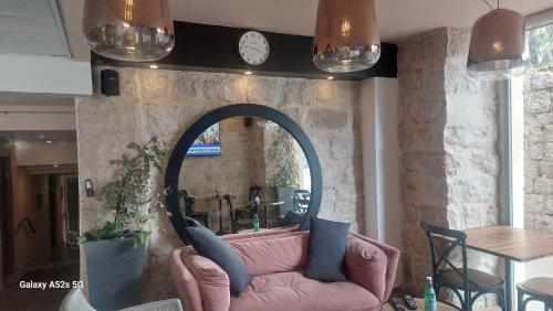 sala de estar con sofá rosa y espejo en heleni malka hotel, en El Muṣrāra