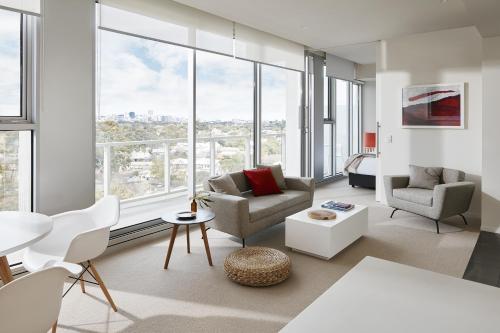 a living room with white furniture and large windows at Art Series - The Watson in Adelaide