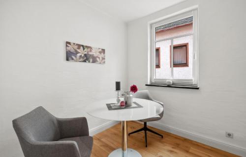 a white room with a table and two chairs and a window at 1 Bedroom Cozy Apartment In Pommern in Pommern