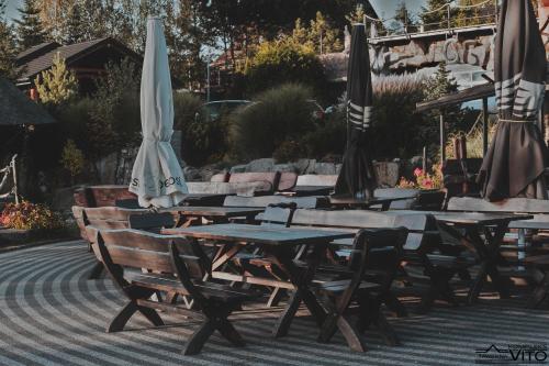 a group of tables and umbrellas on a patio at Kompleks Tawerna Vito - Apartamenty Vito in Czorsztyn