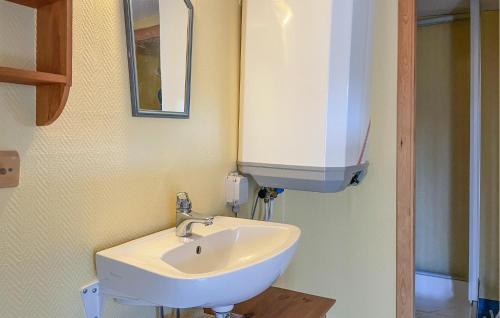 uma casa de banho com um lavatório branco e um espelho. em Beautiful Home In Kil With Wifi em Rolfsbol