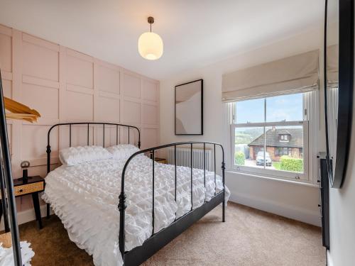 a bedroom with a bed and a window at Ivy Cottage in Belper