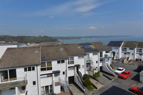 a group of houses with a view of the water at Stylish Saundersfoot Top Floor 2-Bed Seaview Apartment, Balcony & Parking in Pembrokeshire