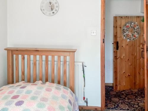a bedroom with a crib and a clock on the wall at Green Shutters in Harmston