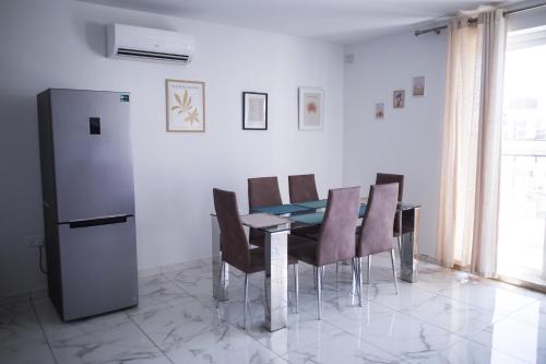 a dining room with a table and chairs and a refrigerator at Cova da Iria 5 in Tal-Pietà