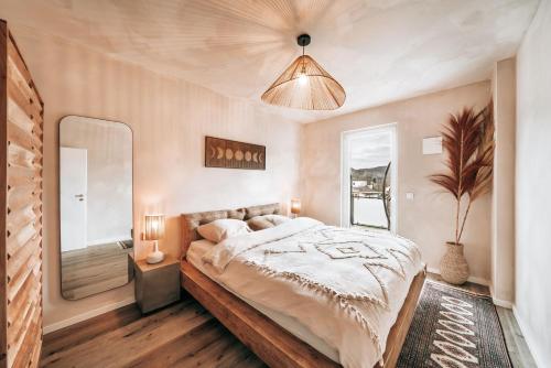 a bedroom with a large bed and a mirror at GetAway Penthouse: Spa & Cinema in Echternacherbrück