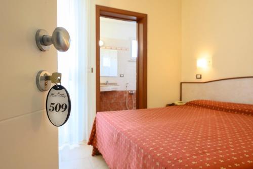 a bedroom with a bed and a sign on the door at Hotel Harmony in Rimini