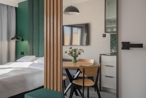 1 dormitorio con 1 cama, mesa y sillas en AVAPARTS apartament GREEEN, en Jastarnia