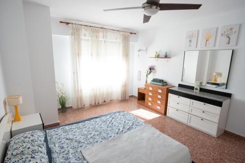 Schlafzimmer mit einem Bett, einer Kommode und einem Spiegel in der Unterkunft An apartment in Xeraco with 3 bedrooms, located near beach and Gandia in Xeraco