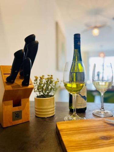 a bottle of wine and two wine glasses on a table at mein Hopfengut by heinkewohnraum in Tettnang