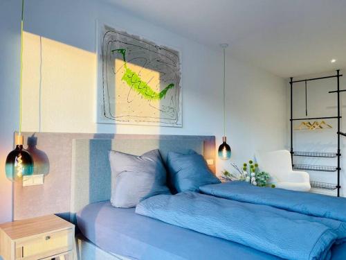 ein Schlafzimmer mit einem blauen Bett und einem Stuhl in der Unterkunft mein Hopfengut by heinkewohnraum in Tettnang