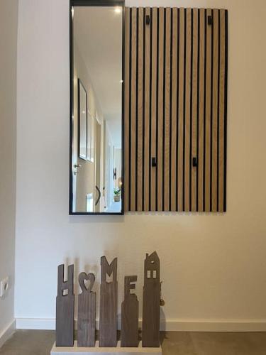 a mirror on a wall with a painting of people at mein Hopfengut by heinkewohnraum in Tettnang