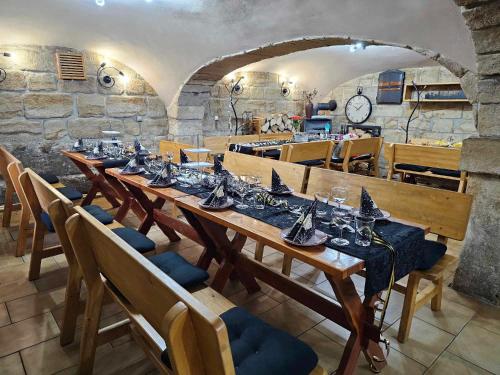 a dining room with a long wooden table and chairs at Penzion u Marešů in Hřensko