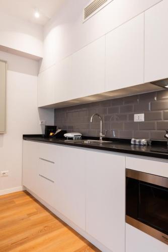 a kitchen with white cabinets and a sink at Major House - Luxury Apartments in Rome by Hostand in Rome