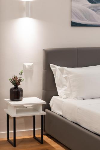 a bed with a nightstand next to a white bed with a lamp at Major House - Luxury Apartments in Rome by Hostand in Rome