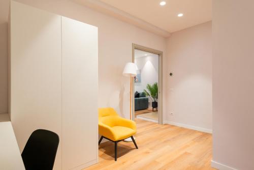 a living room with a yellow chair and a mirror at Major House - Luxury Apartments in Rome by Hostand in Rome