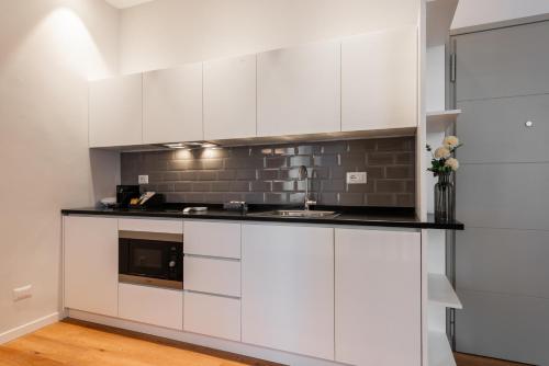 a kitchen with white cabinets and a sink at Major House - Luxury Apartments in Rome by Hostand in Rome