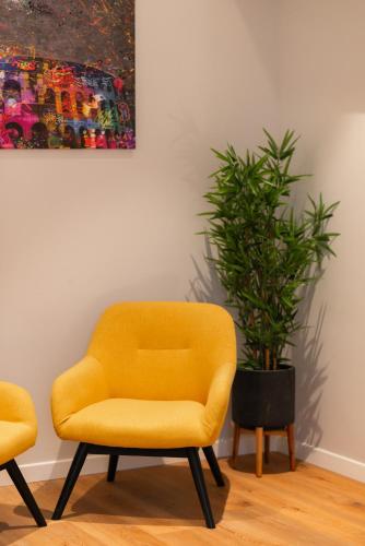 a yellow chair and a potted plant in a room at Major House - Luxury Apartments in Rome by Hostand in Rome