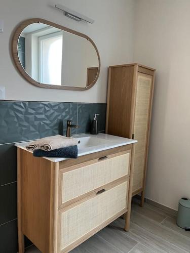 une salle de bain avec un lavabo et un miroir dans l'établissement La Petite Maison, à Vermand