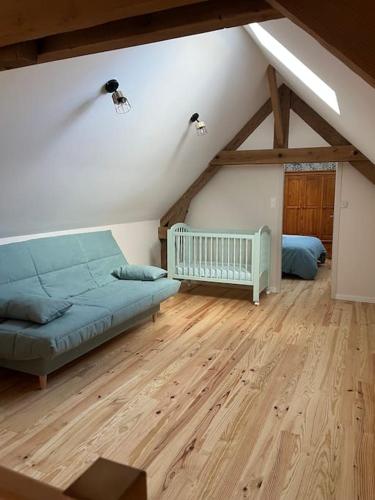 - une chambre mansardée avec un lit et un lit bébé dans l'établissement La Petite Maison, à Vermand