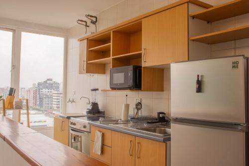 een keuken met een koelkast, een wastafel en een raam bij 12 Floor Carolina Area best view 2br CCI Quito Coliving Ecuador in Quito