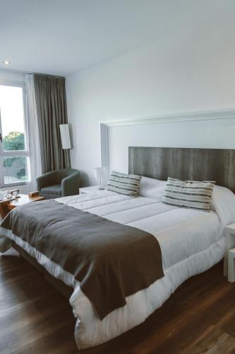 a bedroom with a large bed and a chair at Posta Natural in Tandil