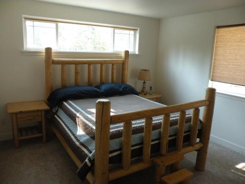 1 dormitorio con cama de madera y ventana en Cozy Cabin LaPine, en La Pine
