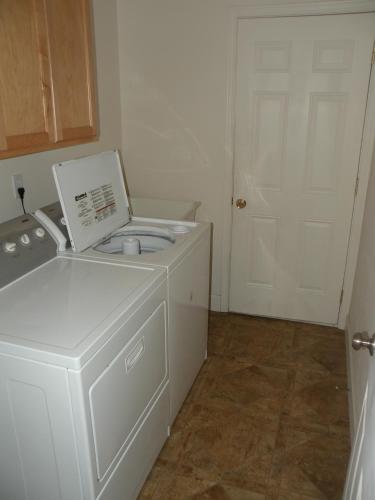 a washer and dryer in a room with a door at Cozy Cabin LaPine in La Pine
