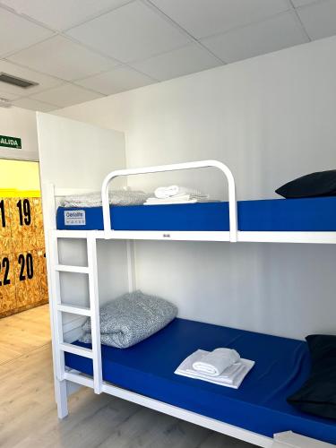 a bunk bed with a blue bottom bunk at Albergue SCQ in Santiago de Compostela