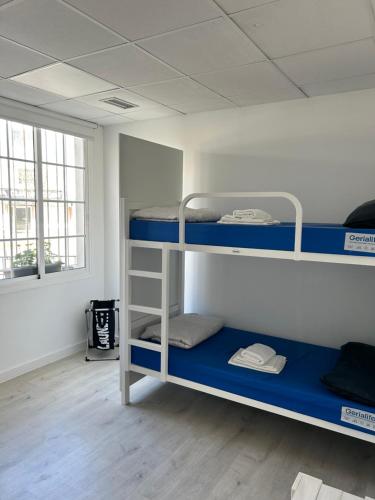 a dorm room with three bunk beds in it at Albergue SCQ in Santiago de Compostela