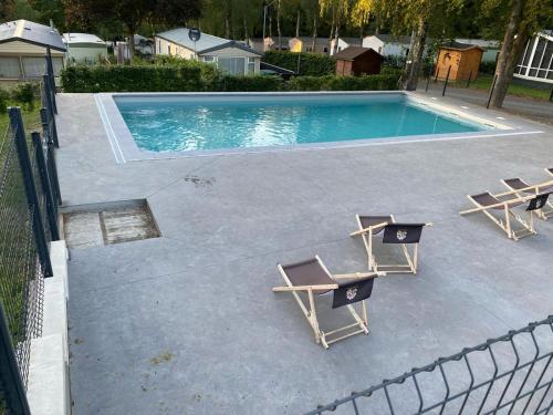 een zwembad met 2 ligstoelen en een tafel bij DeerN'Wood in Trois-Ponts