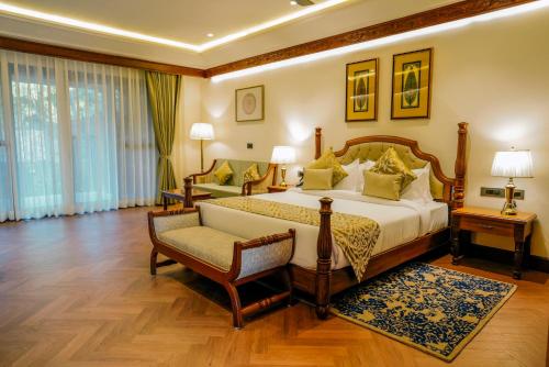 a hotel room with a bed and a chair at Aahana Resort - Jim Corbett in Rāmnagar