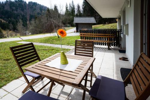 a wooden table with a vase with a flower in it at Apartma Pokljuška idila - Idyllic Pokljuka Studio above Bled in Bled