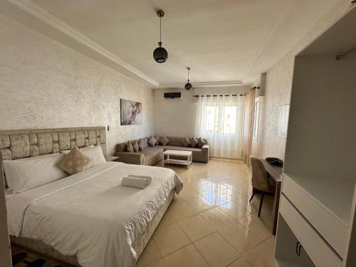 Un dormitorio con una cama grande y un sofá. en Joli Studio vue sur Mer - Gare TGV, en Tánger
