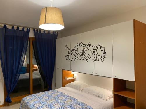 1 dormitorio con 1 cama con cortinas azules en Grazioso monolocale a Pomezia, en Pomezia