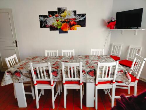 a dining room table with four chairs and a tv at Dandelion home Viareggio centro in Viareggio