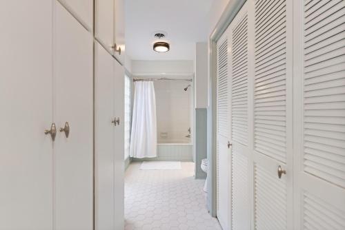 een hal met witte deuren en een badkamer bij Soulful of Sunshine - 4314 Eleventh Street in Saint Simons Island