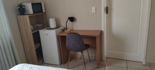 a small desk with a chair next to a refrigerator at Nkulies Nest in Centurion