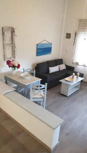 a living room with a table and a couch at EORA Cozy Apartment, kamari Xylokastro in Kamárion