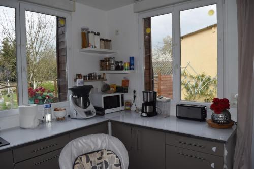 - une cuisine avec un comptoir et 2 fenêtres dans l'établissement Location24hLemans, à La Suze-sur-Sarthe