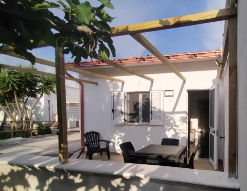 een patio met een tafel en stoelen op een huis bij Casa vacanze Tafuro in Punta Prosciutto