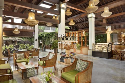 a restaurant with chairs and tables and a bar at Adiwana Unagi Suites in Ubud