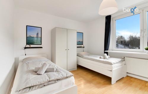 1 dormitorio blanco con 2 camas y ventana en BEGE APARTMENTS WorkAway Residence, en Bochum